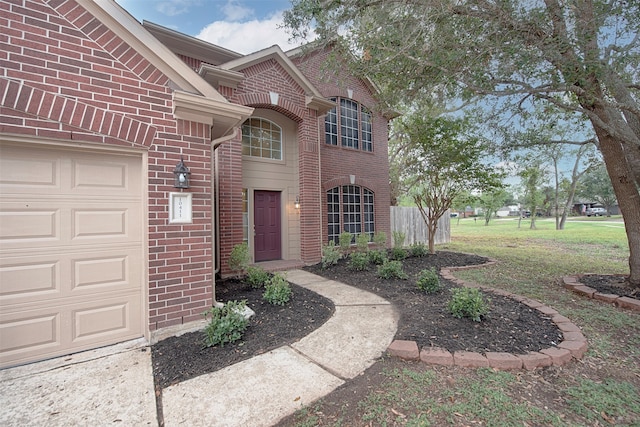 view of exterior entry featuring a yard and a garage