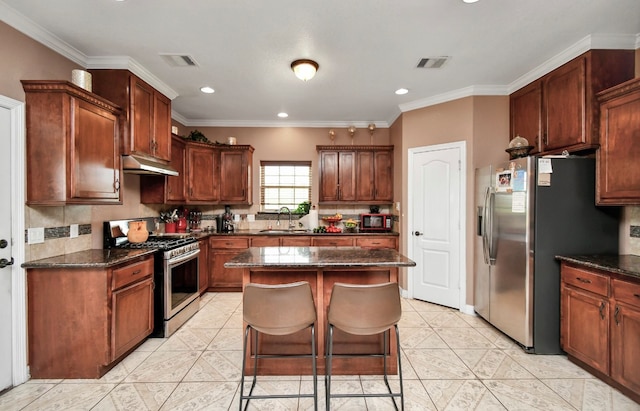 kitchen featuring sink, a center island, stainless steel appliances, dark stone counters, and crown molding