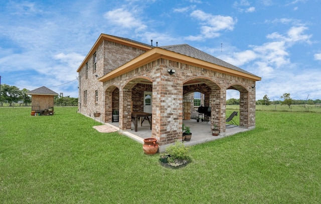 rear view of house with a patio and a lawn