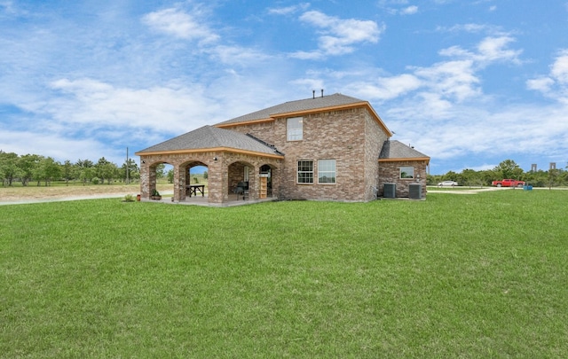 rear view of property with central AC and a lawn