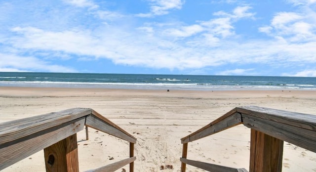 view of home's community with a water view and a beach view