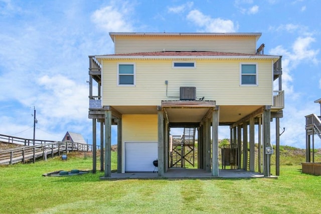 back of property featuring a balcony, central air condition unit, and a lawn