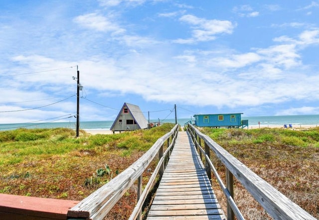 dock area featuring a water view and a beach view