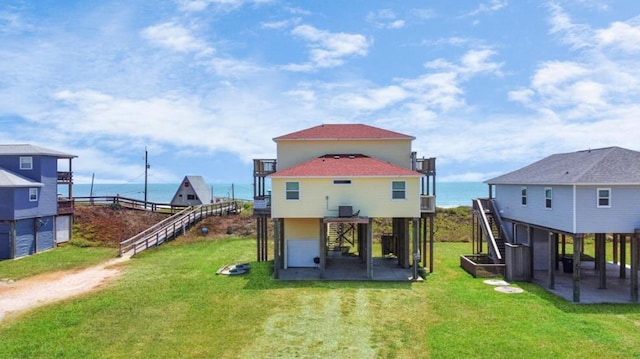 back of house featuring cooling unit, a patio area, a yard, and a water view