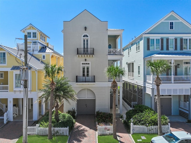 1745 Seaside Dr, Galveston, TX 77550 - view of front of property with decorative driveway, stucco siding, fence, and a balcony