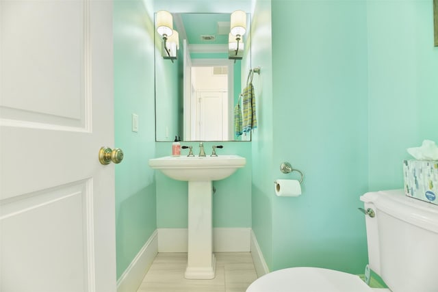1745 Seaside Dr, Galveston, TX 77550 - half bathroom featuring toilet, baseboards, and a sink
