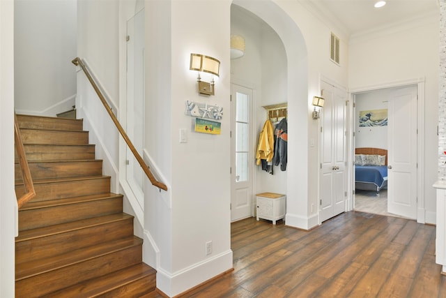 1745 Seaside Dr, Galveston, TX 77550 - stairway featuring wood finished floors, ornamental molding, visible vents, arched walkways, and baseboards