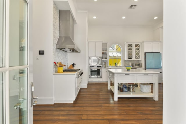 1745 Seaside Dr, Galveston, TX 77550 - kitchen with light countertops, stainless steel appliances, wall chimney range hood, tasteful backsplash, and ornamental molding