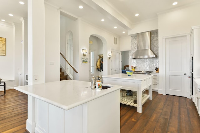 1745 Seaside Dr, Galveston, TX 77550 - kitchen with ornamental molding, wall chimney range hood, arched walkways, and a center island