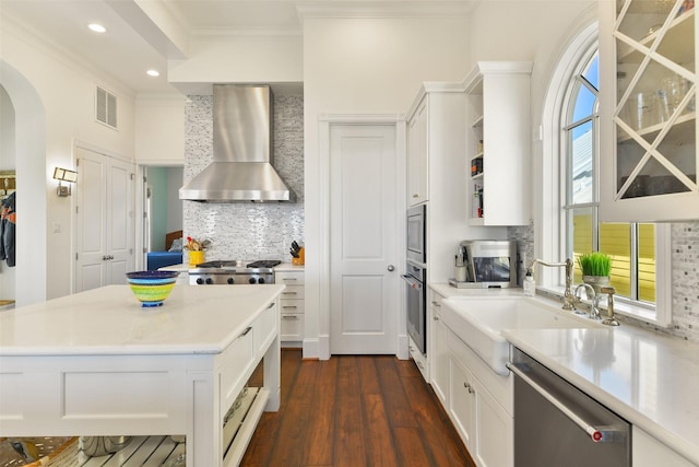 1745 Seaside Dr, Galveston, TX 77550 - kitchen with a sink, visible vents, wall chimney exhaust hood, crown molding, and appliances with stainless steel finishes
