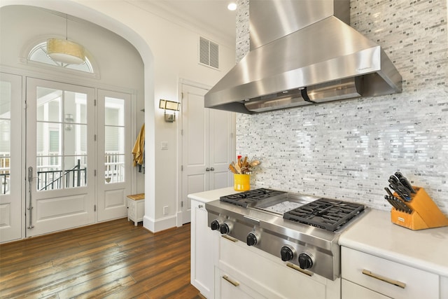 1745 Seaside Dr, Galveston, TX 77550 - kitchen featuring stainless steel gas cooktop, visible vents, dark wood finished floors, wall chimney exhaust hood, and decorative backsplash