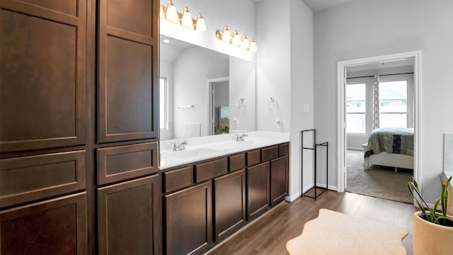 bathroom featuring vanity, lofted ceiling, and hardwood / wood-style flooring