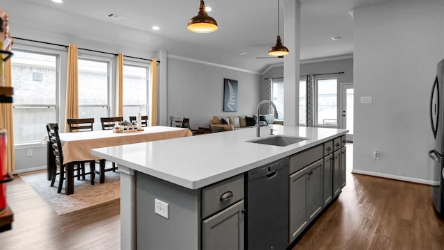 kitchen with black dishwasher, hanging light fixtures, a center island with sink, sink, and dark hardwood / wood-style flooring