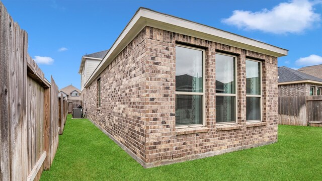 view of property exterior with a yard and cooling unit