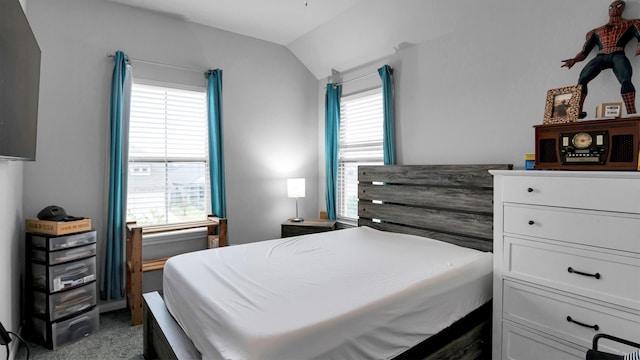 bedroom featuring multiple windows, dark carpet, and vaulted ceiling