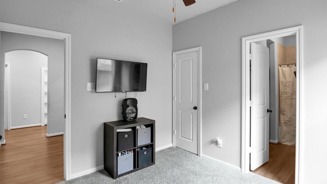 bedroom with connected bathroom, light wood-type flooring, and ceiling fan