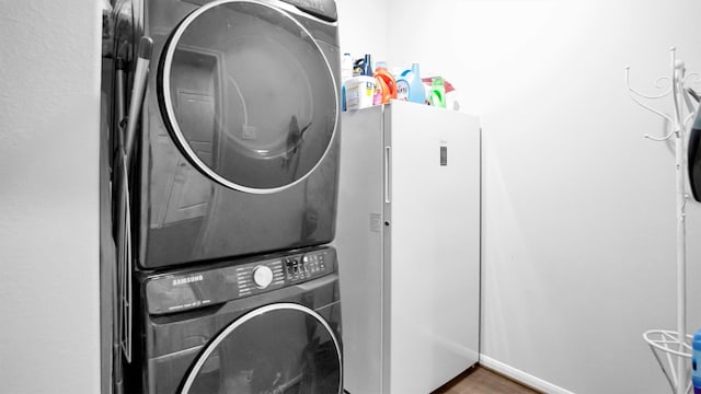 clothes washing area featuring stacked washer / dryer