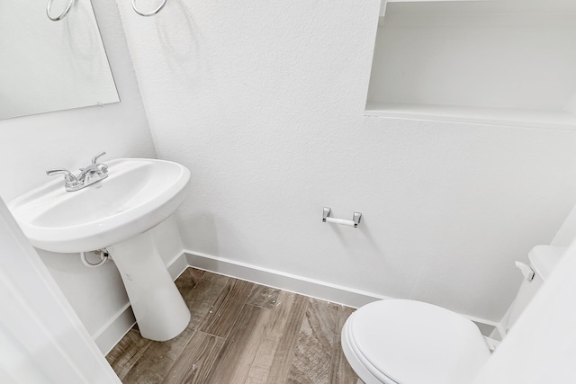 bathroom featuring wood-type flooring and toilet