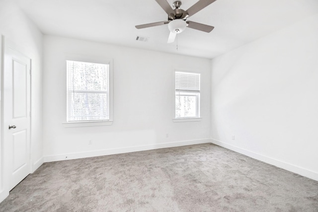 spare room featuring light colored carpet and ceiling fan