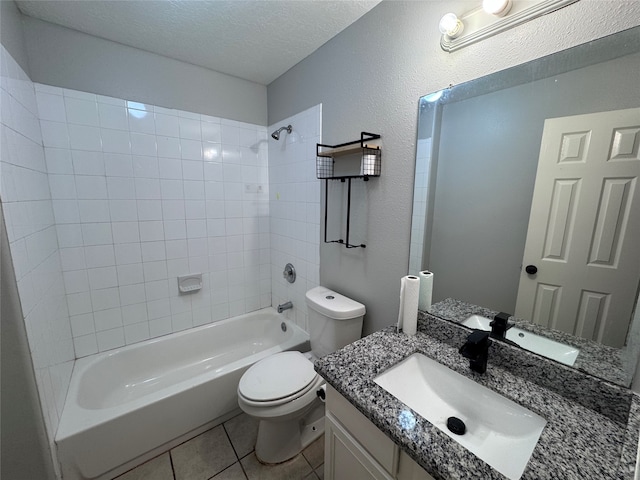 full bathroom featuring toilet, tile patterned flooring, tiled shower / bath, vanity, and a textured ceiling