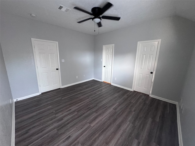 unfurnished room featuring dark wood-type flooring, ceiling fan, and a textured ceiling