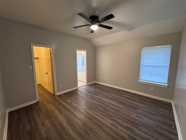 unfurnished bedroom with a spacious closet, ensuite bathroom, dark hardwood / wood-style floors, and ceiling fan