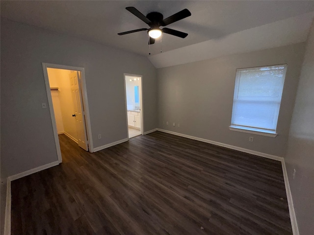 unfurnished bedroom with a walk in closet, ensuite bath, ceiling fan, lofted ceiling, and dark hardwood / wood-style floors