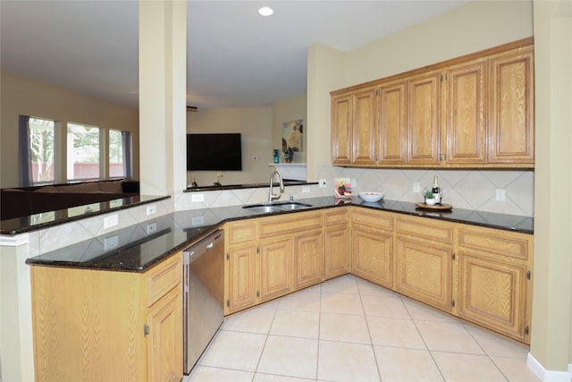 kitchen featuring dark stone counters, decorative backsplash, sink, dishwasher, and kitchen peninsula