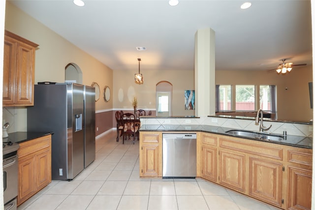 kitchen with stainless steel appliances, sink, kitchen peninsula, ceiling fan, and hanging light fixtures