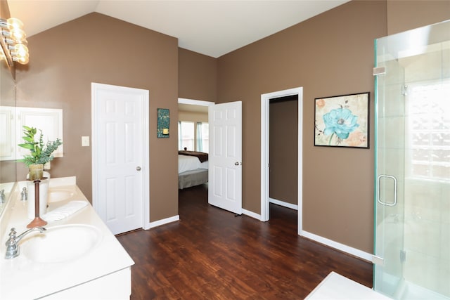 bathroom featuring vanity, hardwood / wood-style floors, lofted ceiling, and a shower with shower door