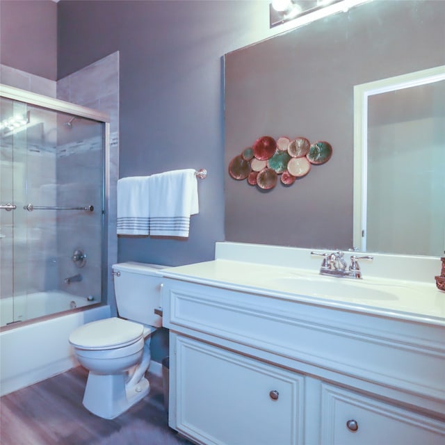 full bathroom with toilet, combined bath / shower with glass door, vanity, and wood-type flooring