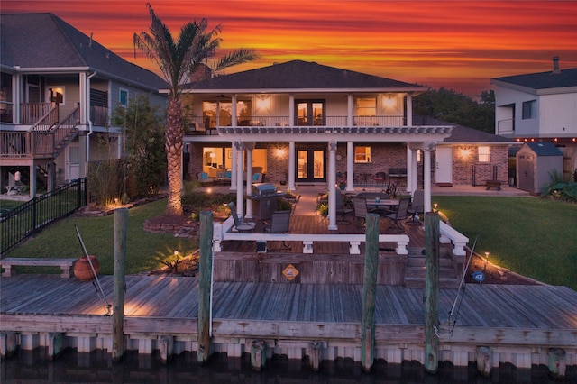 back house at dusk with a balcony and a deck