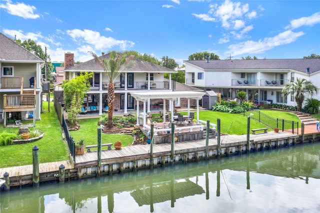 back of house with a balcony, a yard, a patio, and a water view