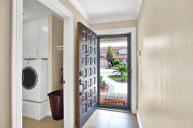 laundry area with cabinets, ornamental molding, a textured ceiling, light tile patterned floors, and washer / dryer