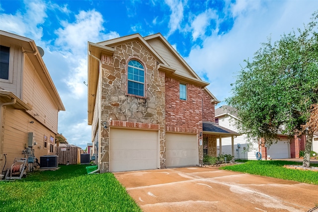 view of front of house with a garage, cooling unit, and a front lawn