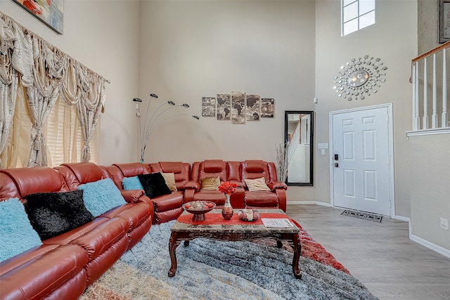 living room featuring a towering ceiling and hardwood / wood-style flooring