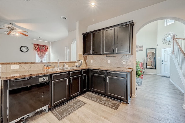 kitchen with sink, light hardwood / wood-style flooring, decorative backsplash, and black dishwasher