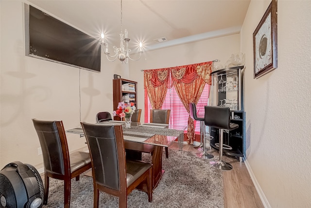 dining room with hardwood / wood-style flooring and a notable chandelier