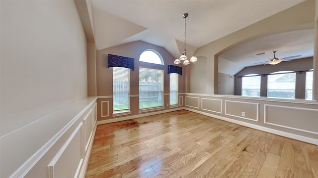 unfurnished dining area featuring vaulted ceiling, light hardwood / wood-style flooring, and a healthy amount of sunlight