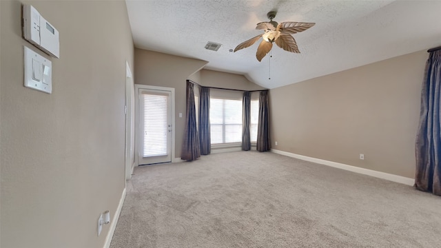 carpeted spare room with lofted ceiling, a textured ceiling, and ceiling fan