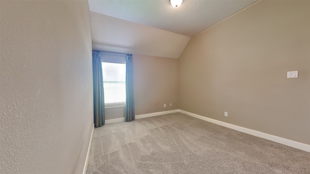 unfurnished room with vaulted ceiling and light carpet