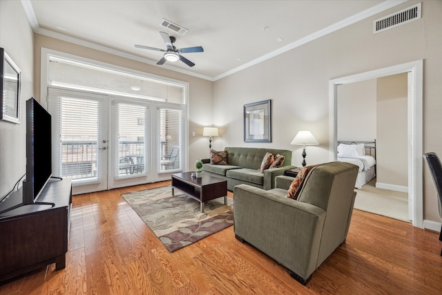 living room featuring light hardwood / wood-style floors, ornamental molding, and ceiling fan