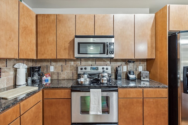 kitchen featuring dark stone countertops, stainless steel appliances, and decorative backsplash