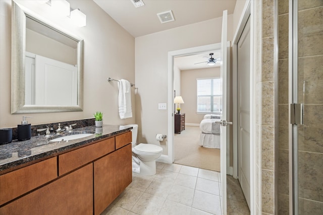 bathroom featuring a shower with shower door, toilet, ceiling fan, tile patterned floors, and vanity