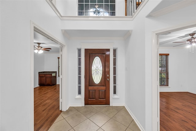 entryway with crown molding, light hardwood / wood-style flooring, and ceiling fan