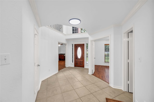 foyer entrance featuring light hardwood / wood-style floors, crown molding, and ceiling fan