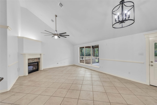 unfurnished living room with light tile patterned flooring, high vaulted ceiling, ceiling fan with notable chandelier, and a fireplace