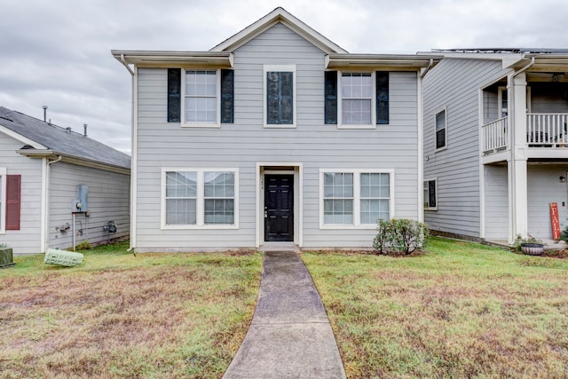 view of front of house with a balcony and a front yard