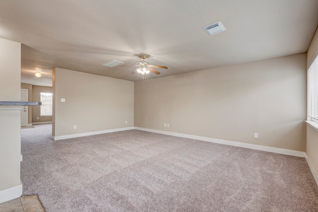 empty room featuring light colored carpet and ceiling fan