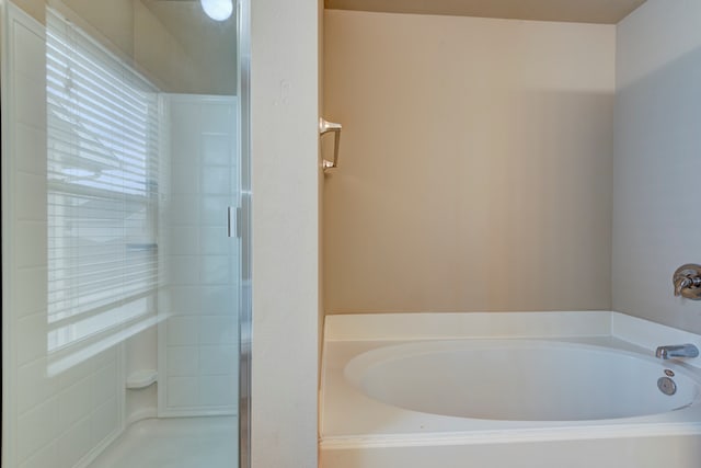 bathroom featuring shower with separate bathtub